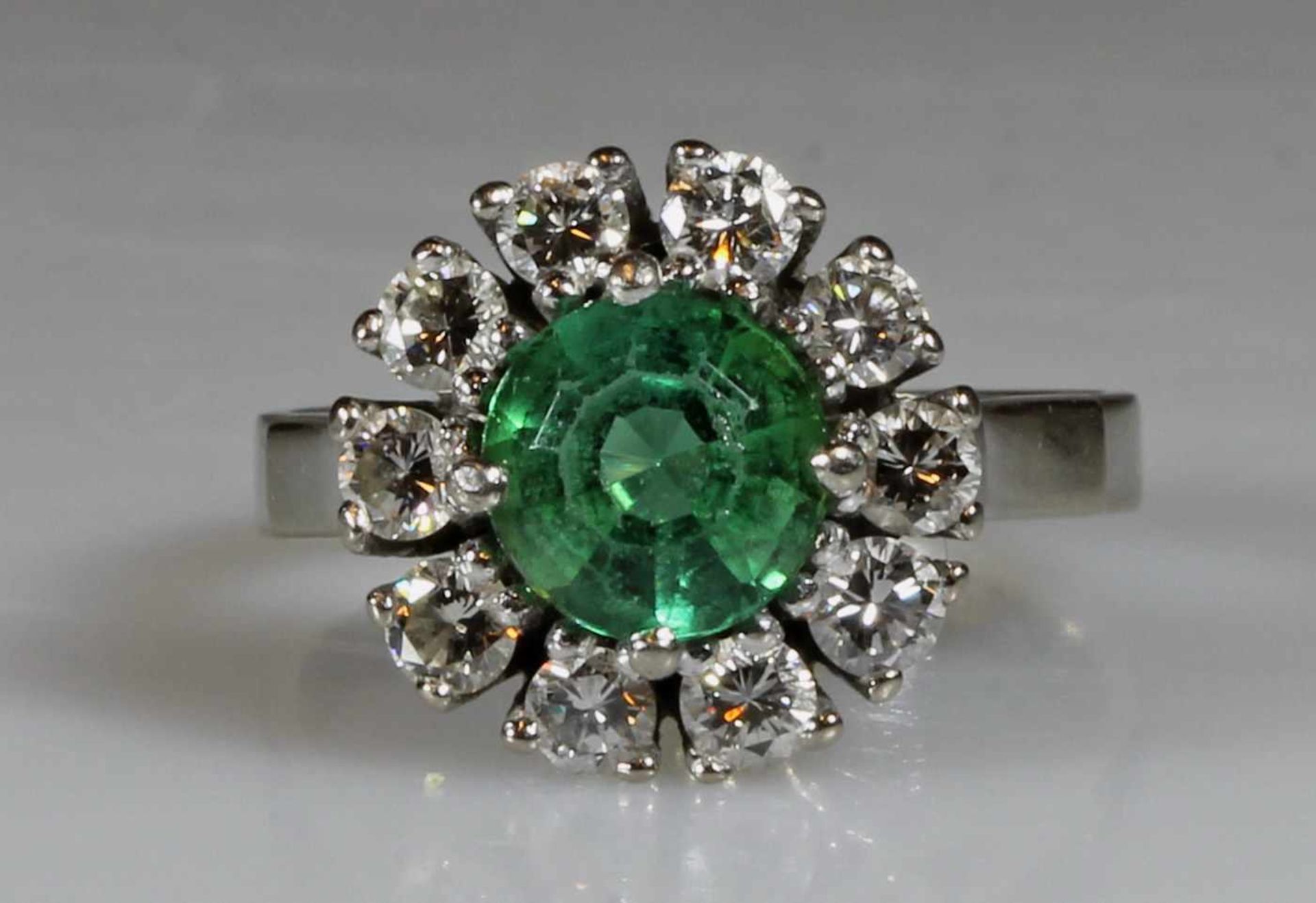 Ring, WG 585, 1 runder facettierter Smaragd, 10 Brillanten zus. ca. 1.0 ct., 6 g, RM 17.5