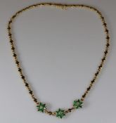 Collier, GG 750, 18 facettierte Smaragdtropfen ca. 5 x 3 mm, gute Farbe, 3 Brillanten zus. ca. 0.