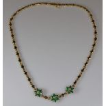 Collier, GG 750, 18 facettierte Smaragdtropfen ca. 5 x 3 mm, gute Farbe, 3 Brillanten zus. ca. 0.