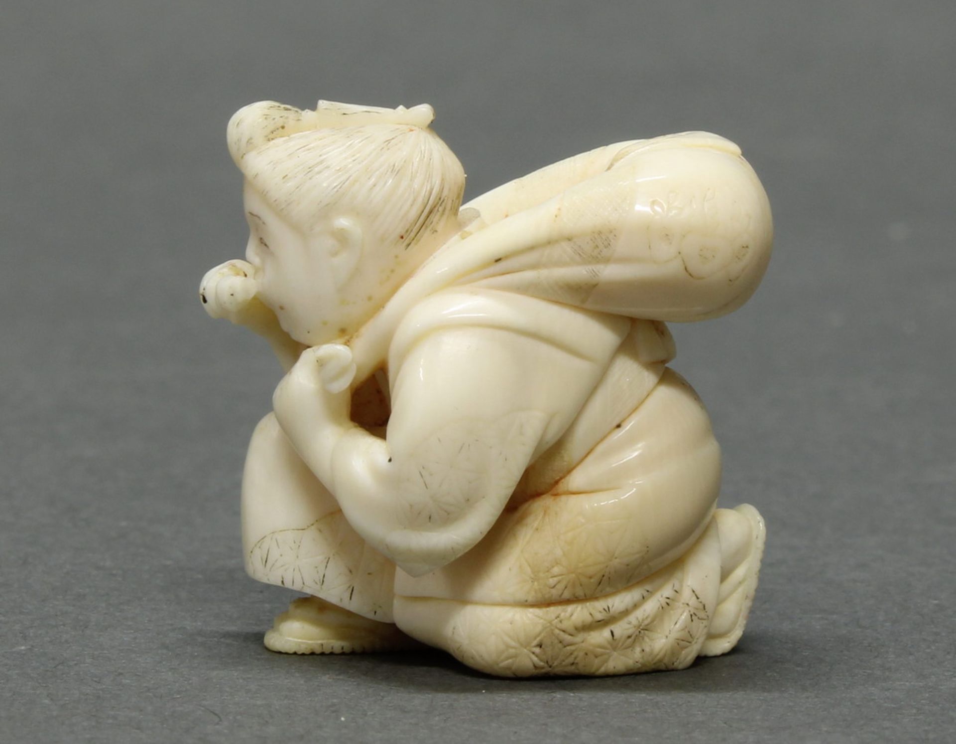 Netsuke, "Wanderer", Japan, um 1900, maritimes Elfenbein, geschnitzt, rotes Signaturplättchen, Reste - Image 2 of 4