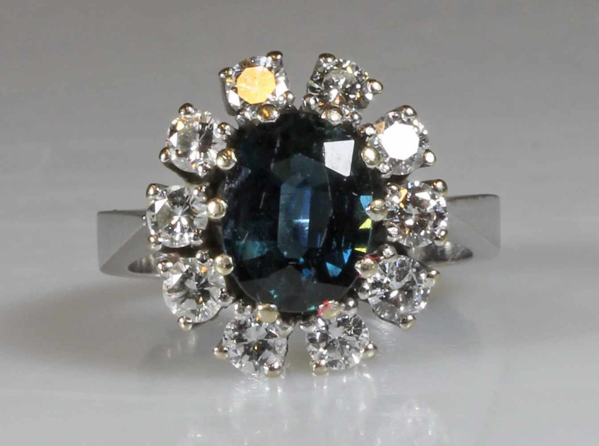 Ring, WG 585, 1 ovaler facettierter Saphir gepunzt 2.42 ct., 10 Brillanten gepunzt (zus.) 1.18