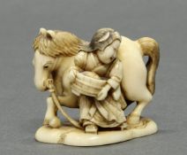 Netsuke, "Frau mit Trog und Pferd", Japan, 19. Jh., Elfenbein, geschnitzt, stellenweise farbig, am