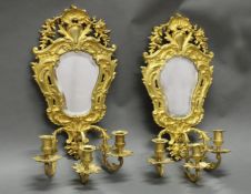 Paar Wandblaker, Frankreich, 19. Jh., je dreiflammig, Bronze feuervergoldet, facettierter Spiegel,