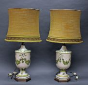 2 Salonlampen, 20. Jh., urnenförmiger Porzellanschaft mit grünem Girlandendekor, Holzplinthe,