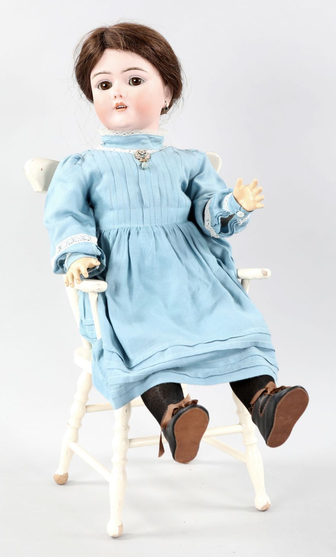 Porzellankopf-Puppe auf Puppenstuhl