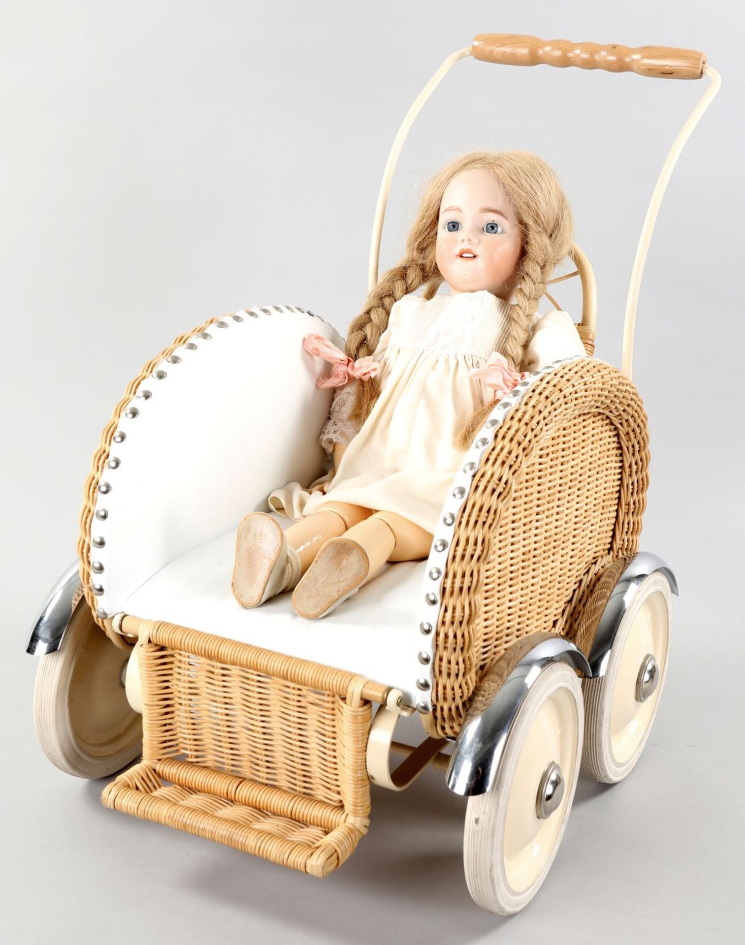 Porzellankopf-Puppe im Kinderwagen