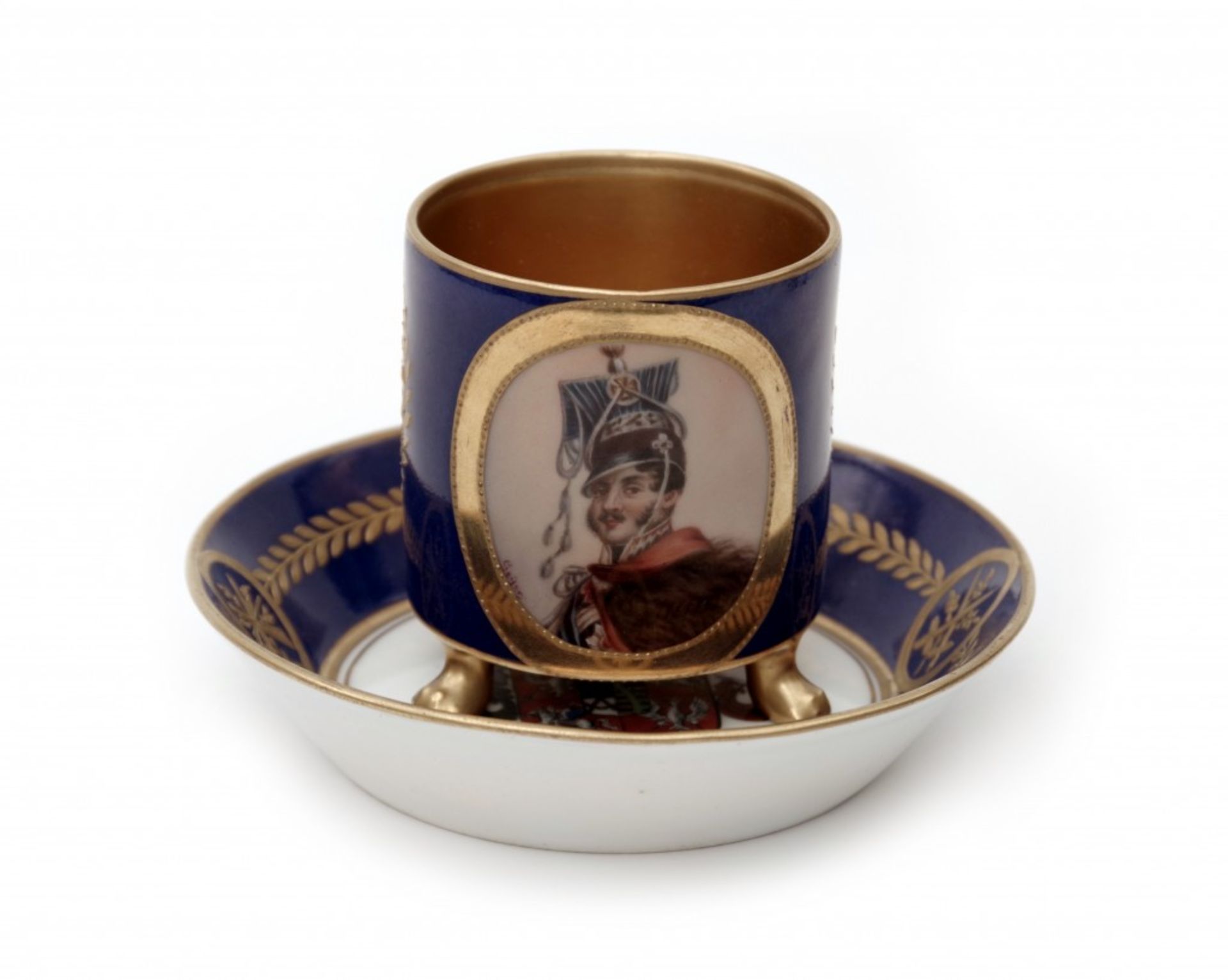 An Empire Style Cup and SaucerPorcelain, cylindrical shaped cup with a bracket handle raised on