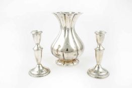 A pair of candlesticks and a vase