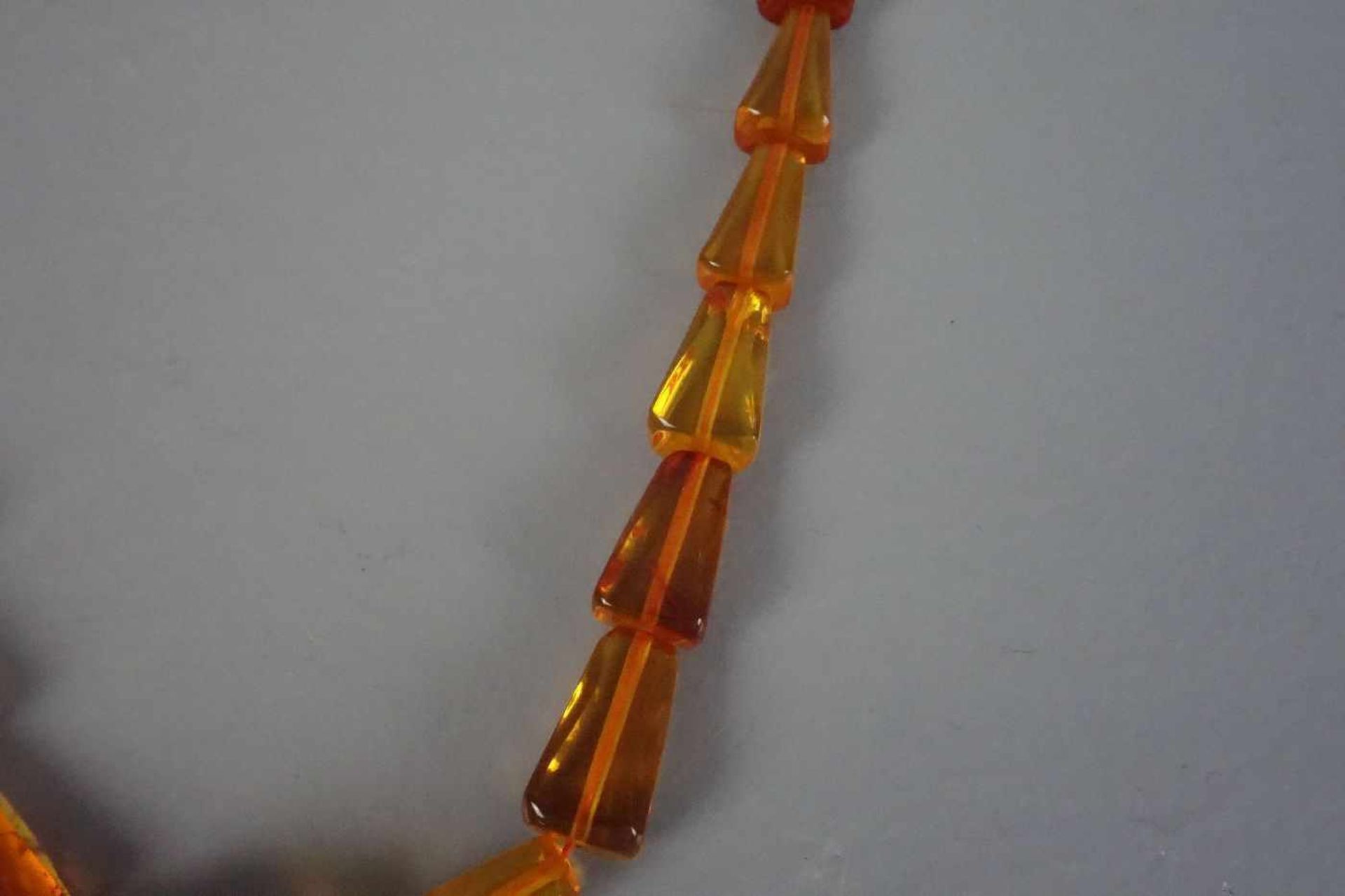 BERNSTEINKETTE / necklace, 1930er Jahre. Klargelbe, gekantete Bernsteinelemente in Größen zwischen 1 - Image 2 of 2