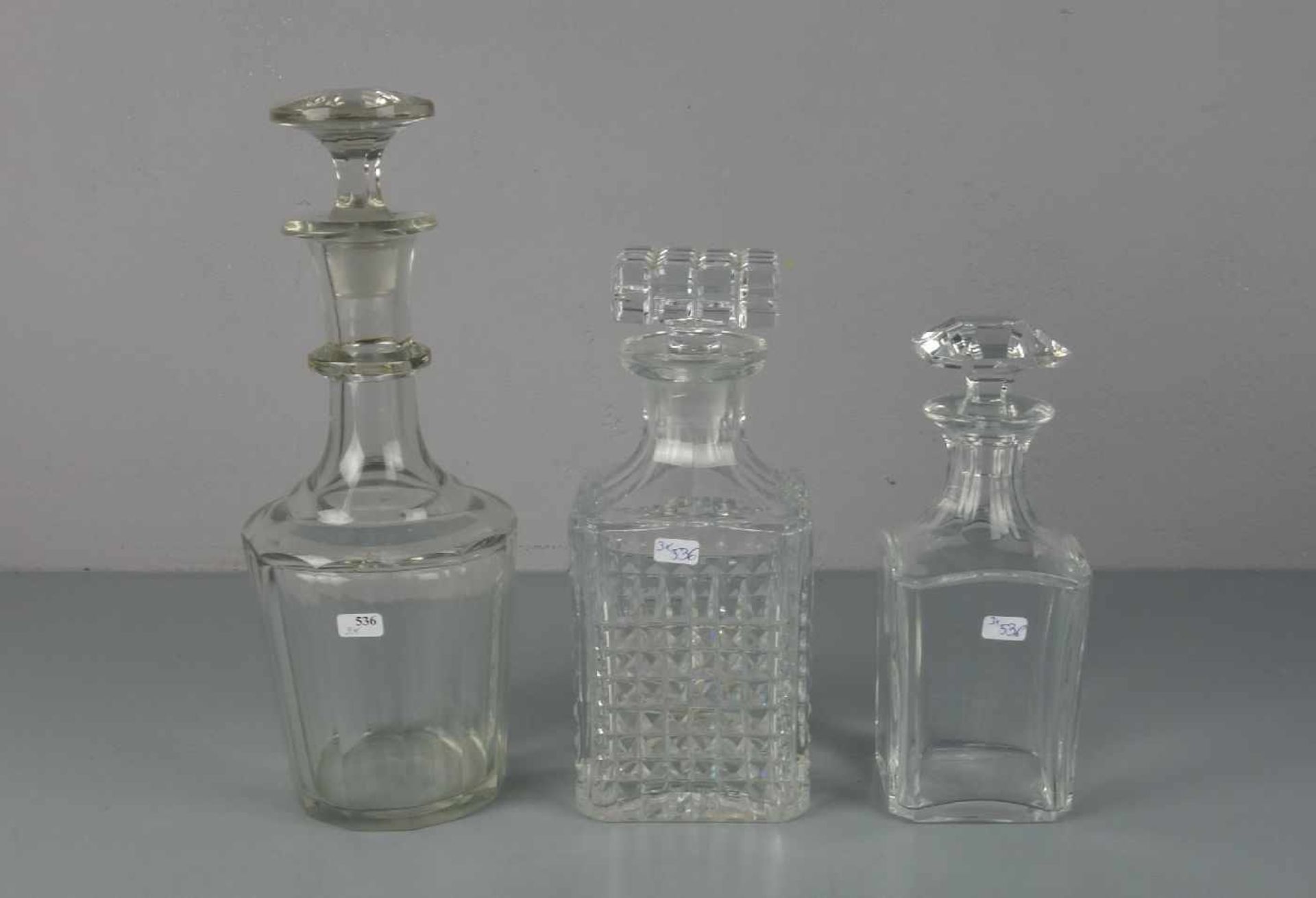 3 GLASKARAFFEN / 3 carafes, Bleikristall, unterschiedliche Formen, Größen und Dekore. H. 21 cm, H.