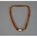 BERNSTEINKETTE / necklace, 1930er Jahre. Klargelbe, gekantete Bernsteinelemente in Größen zwischen 1