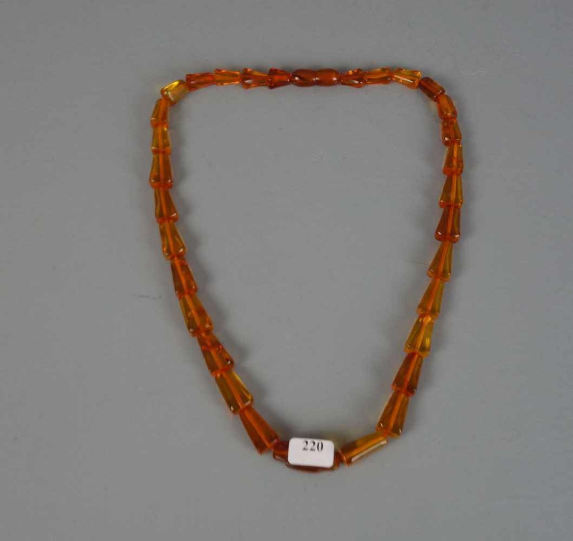 BERNSTEINKETTE / necklace, 1930er Jahre. Klargelbe, gekantete Bernsteinelemente in Größen zwischen 1