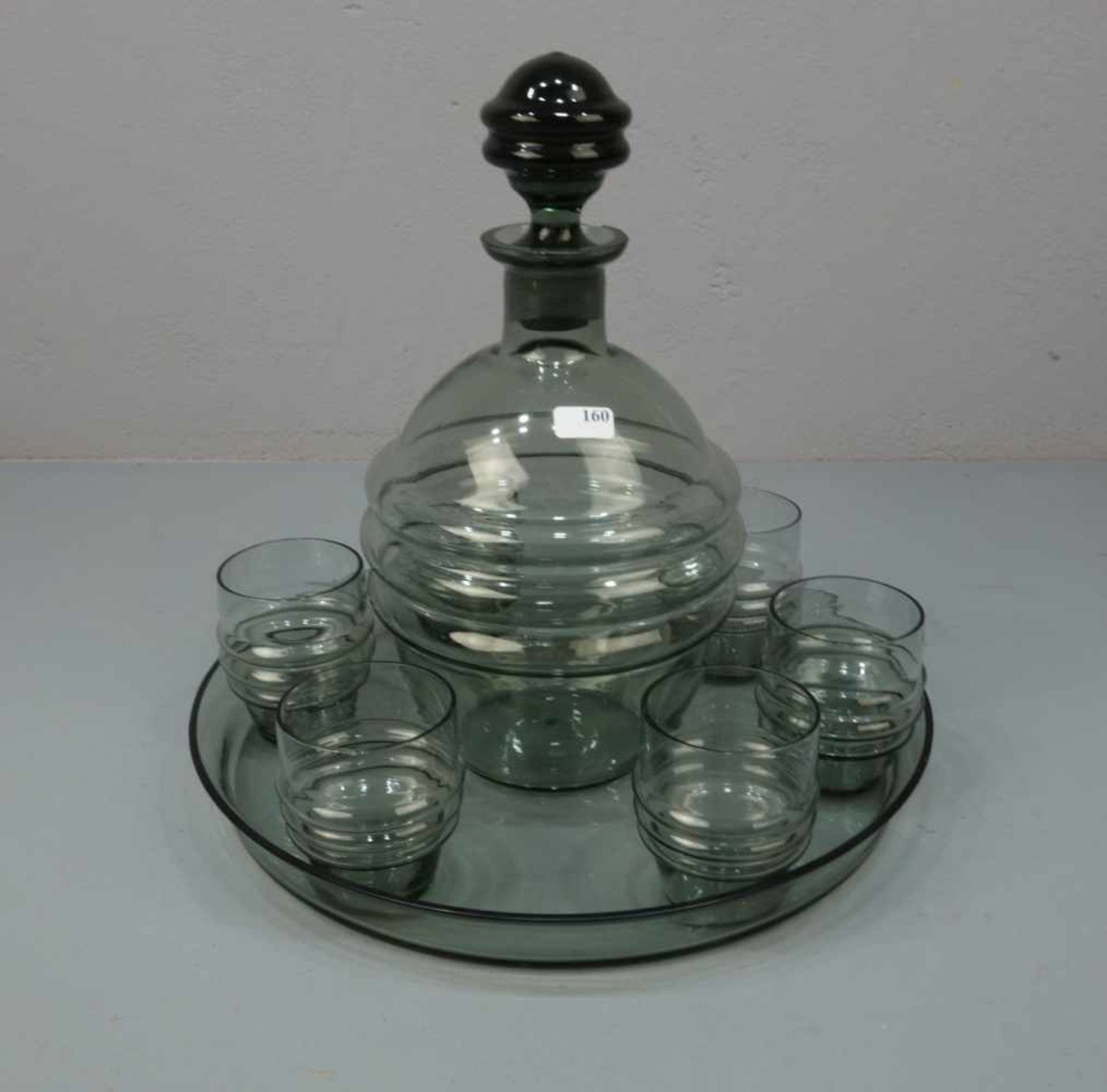 ART DÉCO - LIKÖRSET: Karaffe und 6 Gläser auf Tablett, Rauchglas, grau gefärbt, um 1920. Rundes