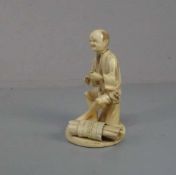 ELFENBEINFIGUR "Sitzender Mann mit Bündel" / Okimono Figur / ivory figure, Japan, wohl 19. Jh. (