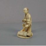 ELFENBEINFIGUR "Sitzender Mann mit Bündel" / Okimono Figur / ivory figure, Japan, wohl 19. Jh. (
