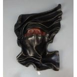 LEDERRELIEF / MASKE "Tuareg", Leder, schwarz und rotbraun, geprägt und gefaltet, vertieft in