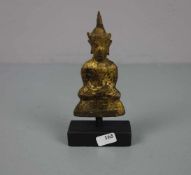 KLEINER BUDDHA AUF HOLZPOSTAMENT, Thailand, 18. Jh., Bronze mit goldfarbener Patinierung. Ein in der