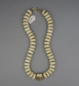 KETTE / BEINKETTE / necklace, mit gold- und silberfarbenen Metallanteilen. Im Zentrum spiral- oder