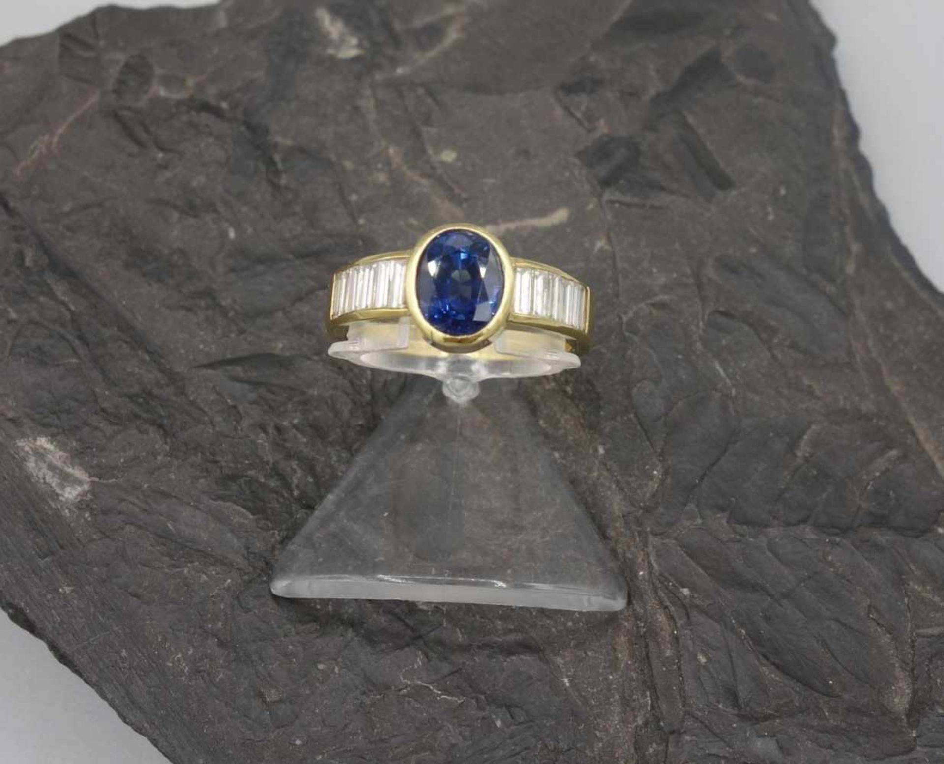 RING MIT SAPHIR UND BAGUETTEBRILLANTEN, massiv gearbeitet, 750er Gelbgold (7,7 g), Ringkopf mit oval