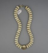 KETTE / BEINKETTE / necklace, mit gold- und silberfarbenen Metallanteilen. Im Zentrum spiral- oder