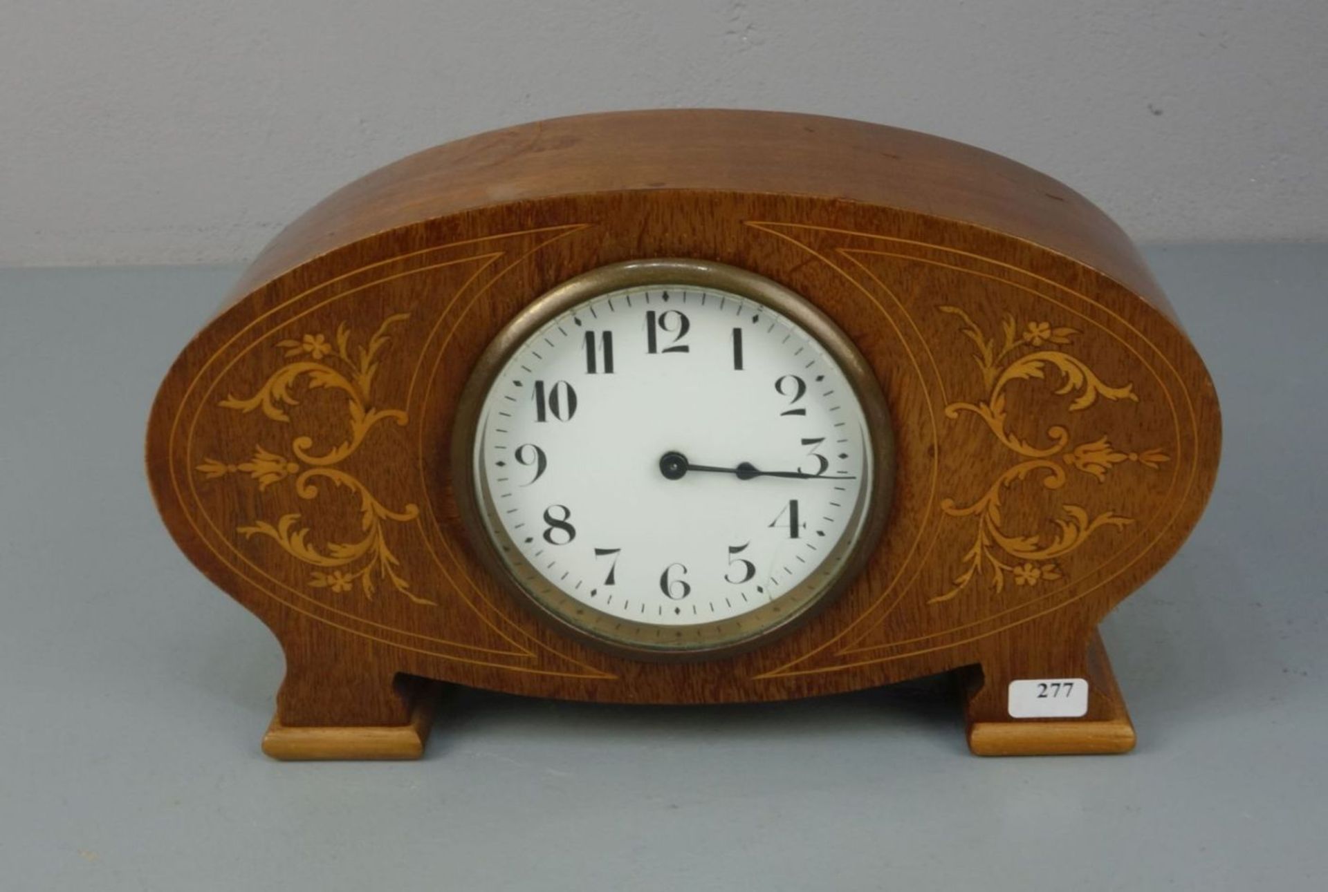 TISCHUHR / KAMINUHR / fire place clock, um 1920. Ovales Gehäuse auf zwei Füßen, dekoriert mit