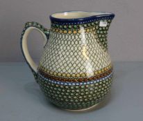 KRUG / jug, Keramik. Bauchiger Krug mit seitlicher Handhabe und Ausguss auf rundem Stand, gefertigt