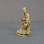 ELFENBEINFIGUR "Sitzender Mann mit Bündel" / Okimono Figur / ivory figure, Japan, wohl 19. Jh. (