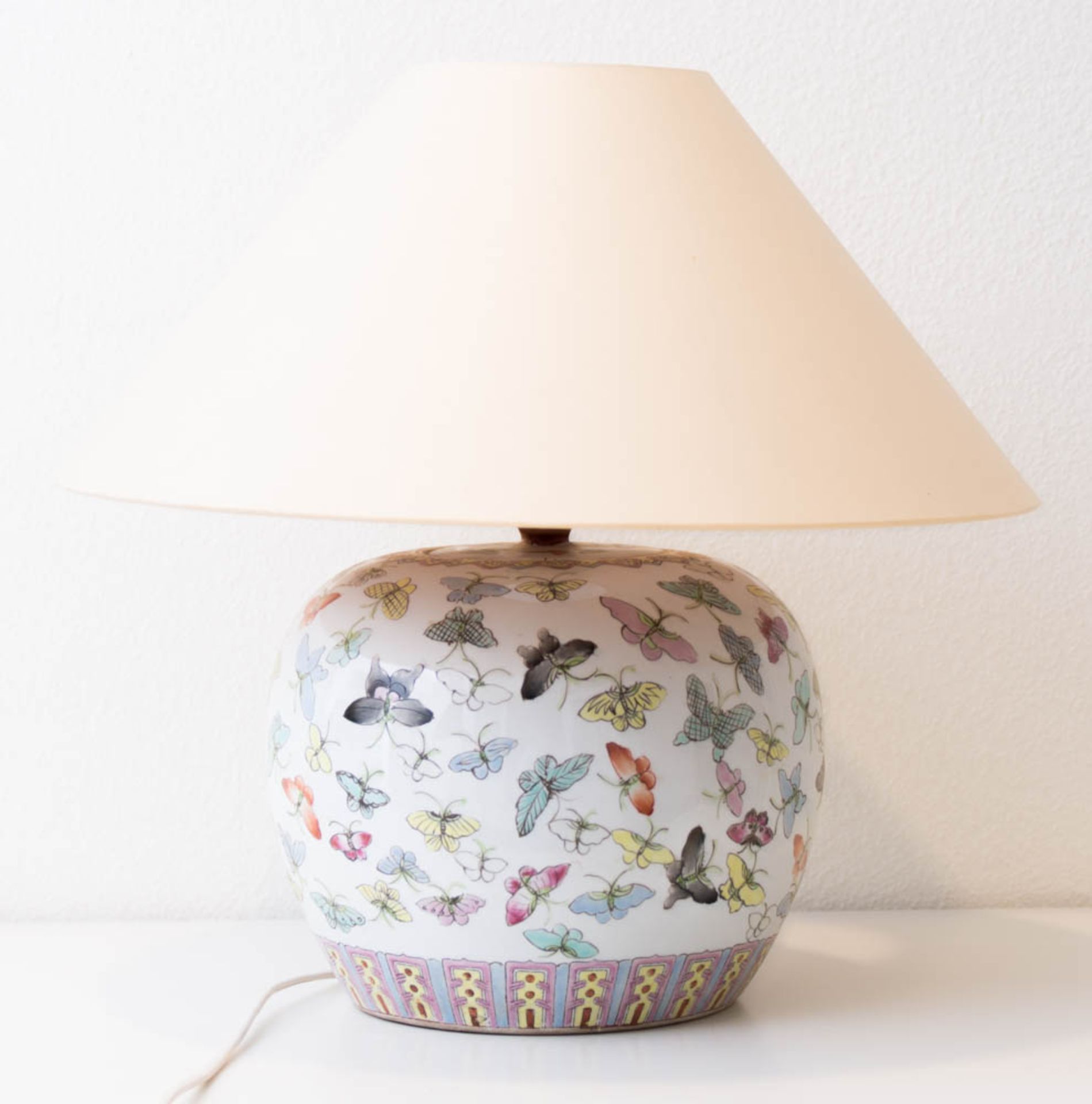 Tischlampe aus Porzellan mit Schmetterlingsdekor.