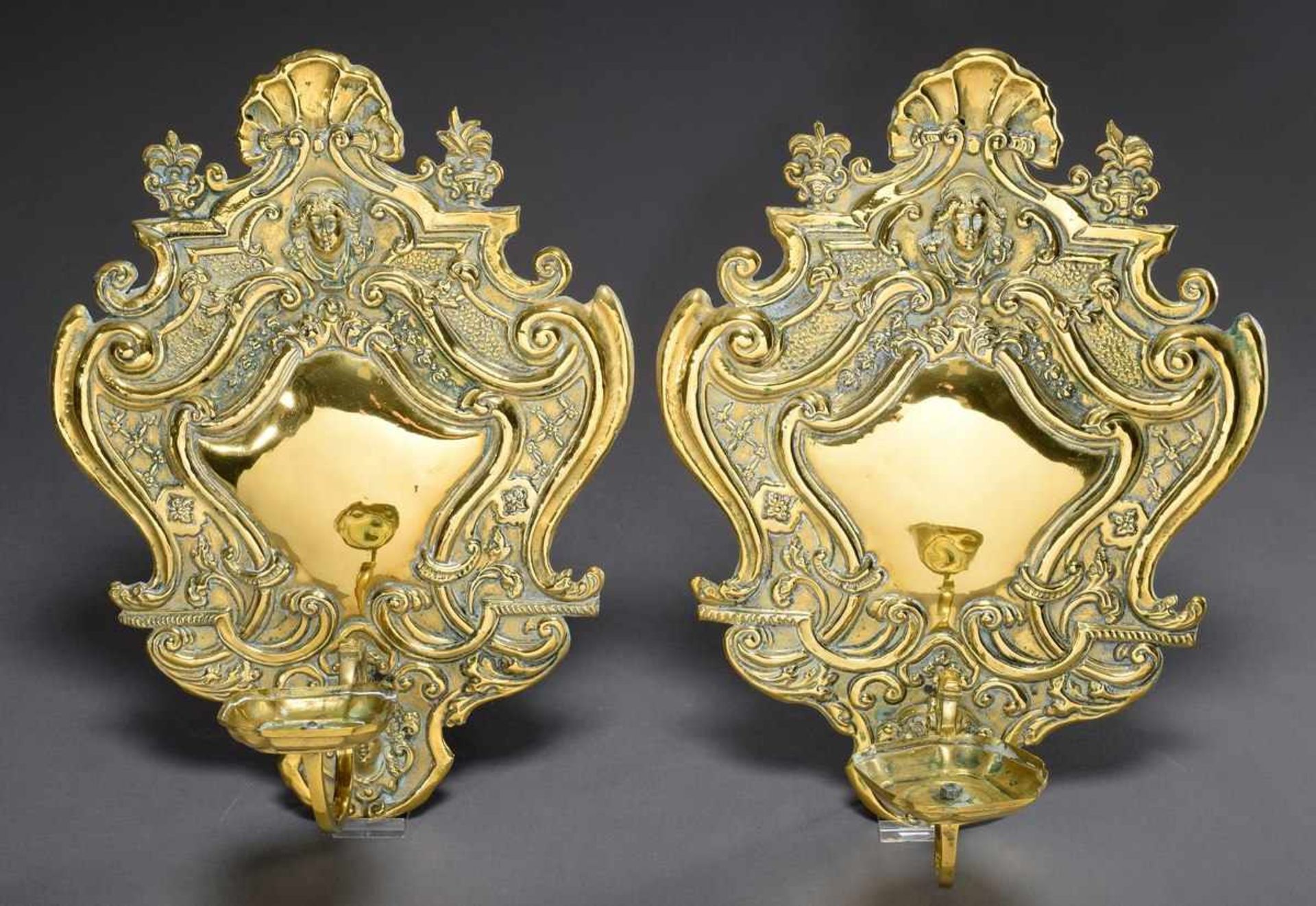 Pair of brass wall blacks with plastic mascarons and volute decoration, 44x32cm, small defects,
