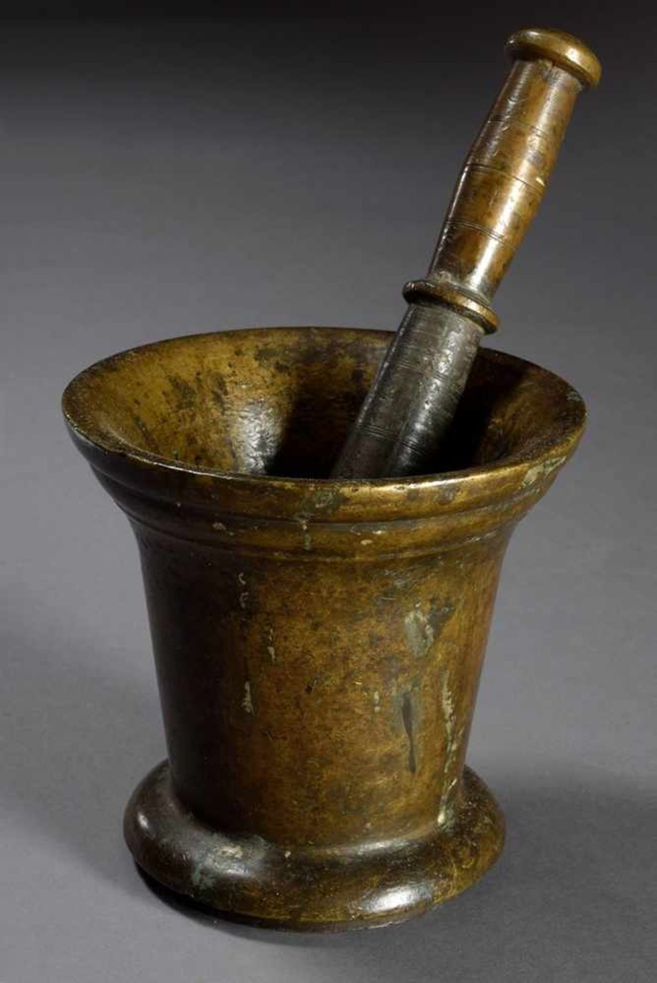 Heavy bronze mortar with funnel-shaped body and overhanging mouth on plate base, probably 17th