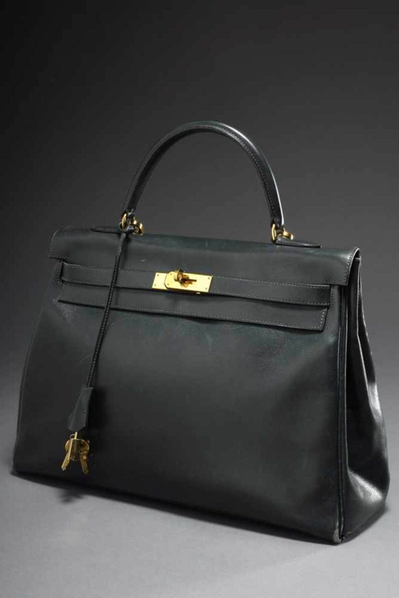 Hermès "Kelly Bag 35 Petit Sac Haut à Courroies", dark green calfskin, trapezoid body with arched