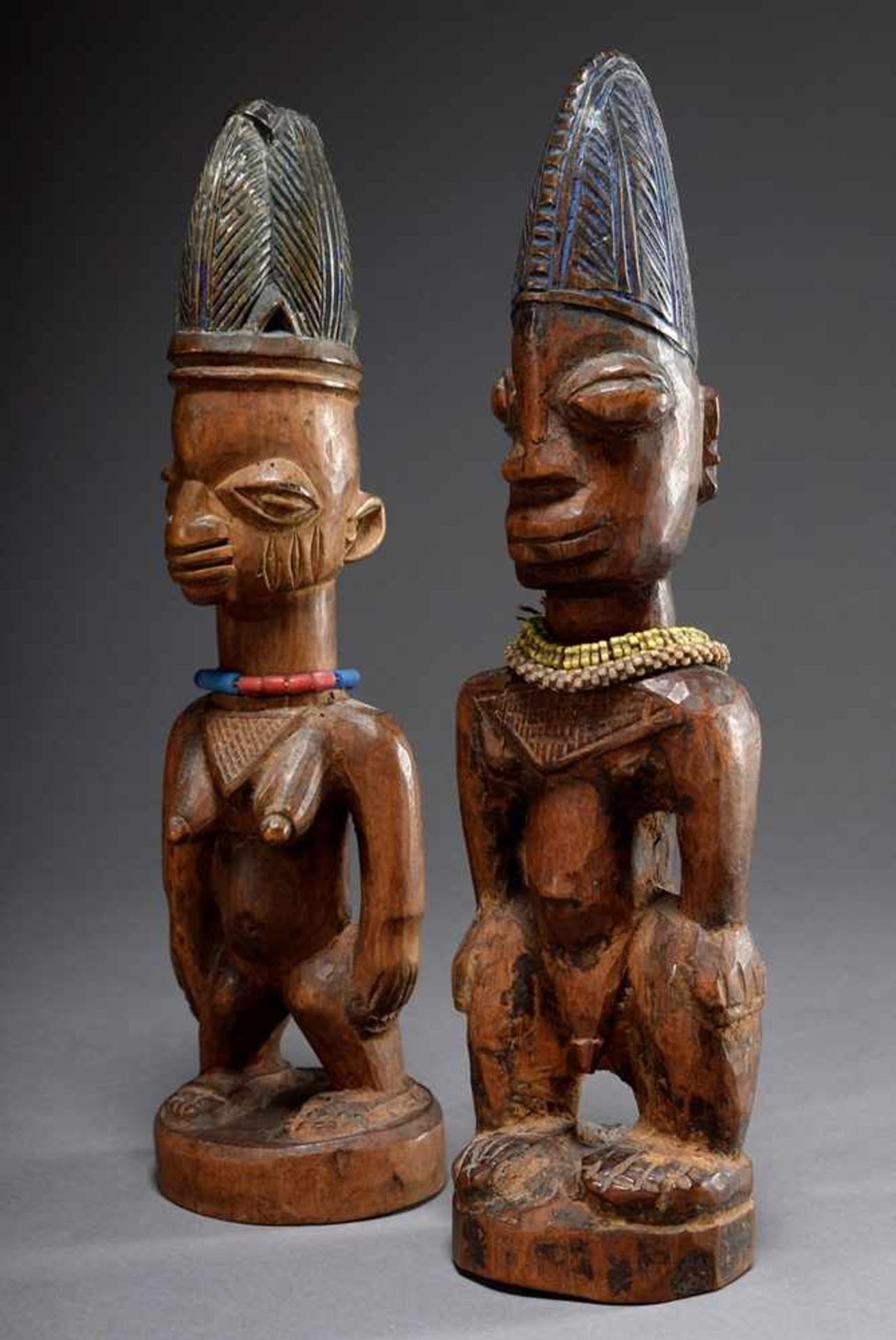 Pair of wooden Ibeji figures with pearl ornaments and remains of coloured painting, h. 19,5/30cm,