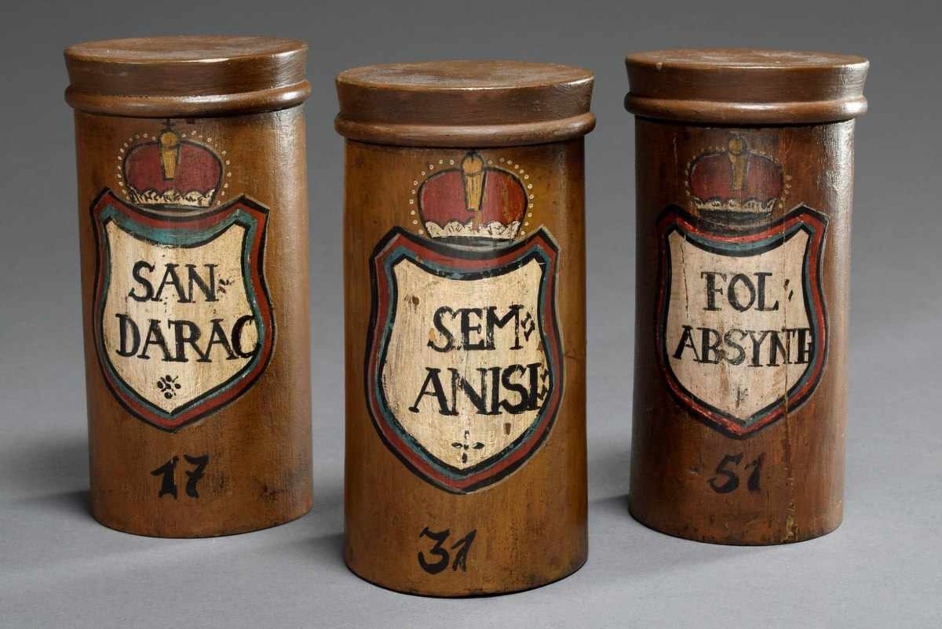 3 Various antique wooden pharmacist's lidded vessels with colored cartridges and inscription "Fol: