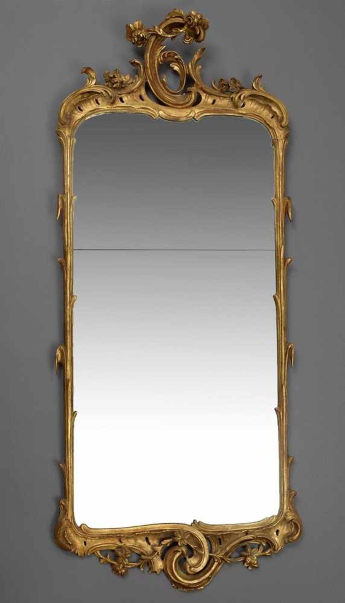 Gilded rococo mirror with carved wooden leaf frame and plastic flowers, probably Holland 18th