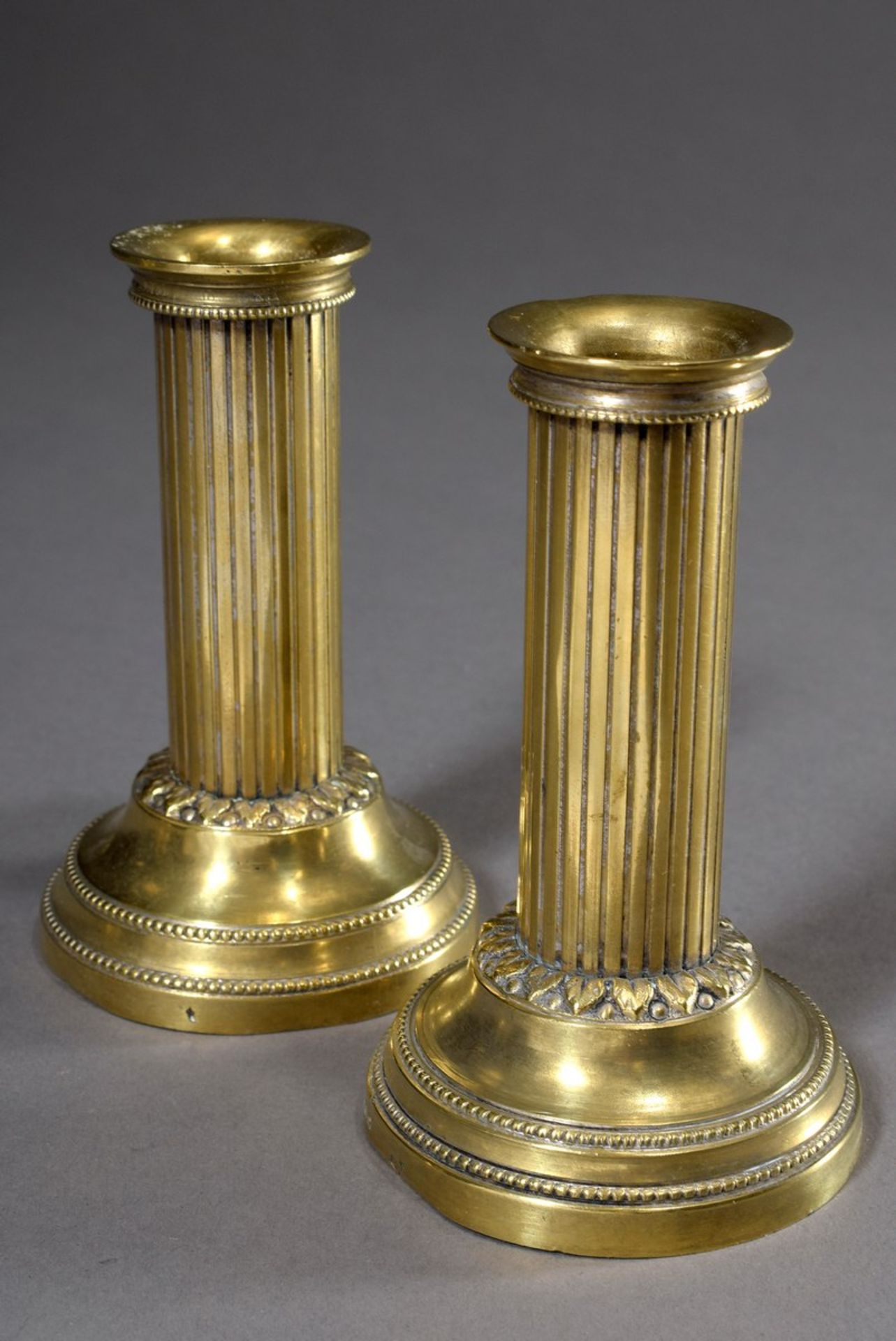 Paar kleine Messing Säulenleuchter mit Blatt- und Perlfries über rundem Fuß, H. 11,5cm,