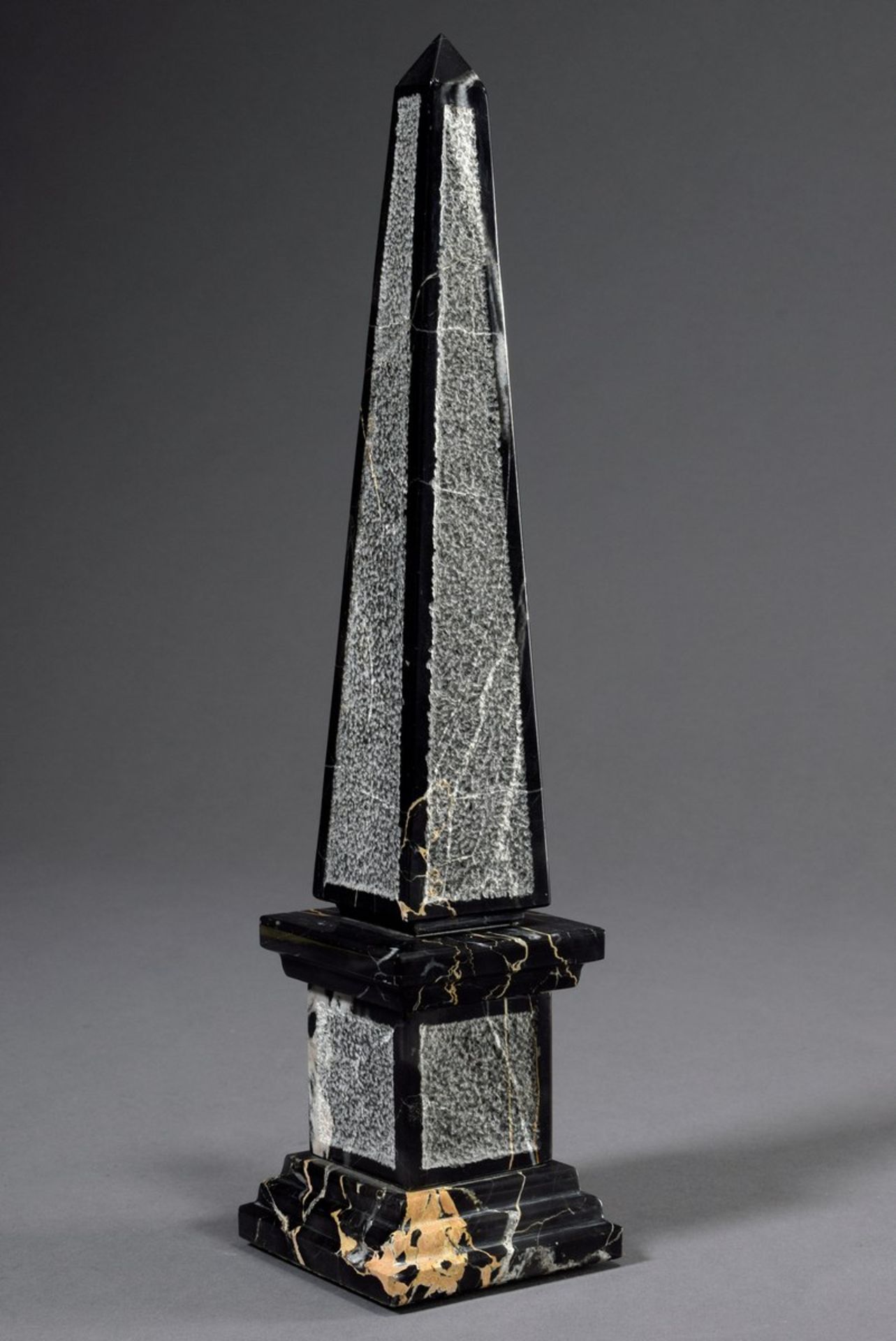 Dekorationsobelisk, schwarzer Marmor mit heller Äderung, partiell bossiert, H. 35,5cm, min.