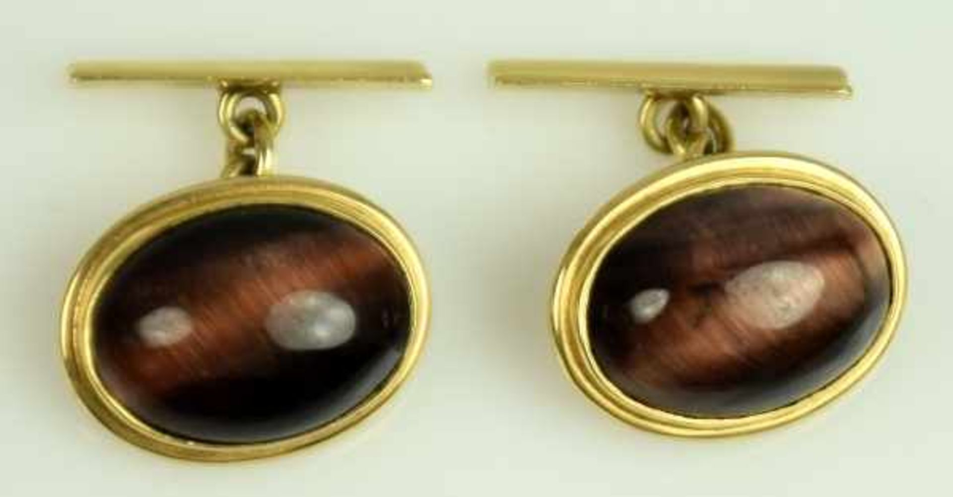 PAAR MANSCHETTENKNÖPFE oval, mit braunem Katzenaugen-Cabochon besetzt, in Gelbgoldfassung 14ct, 12,