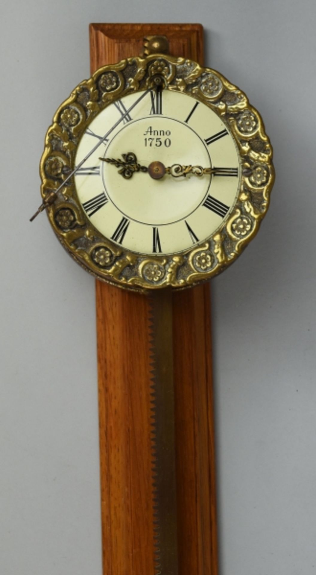 SÄGEUHR als Wanduhr, rundes Uhrengehäuse mit reliefiertem Blütenrand aus Messing mit rundem