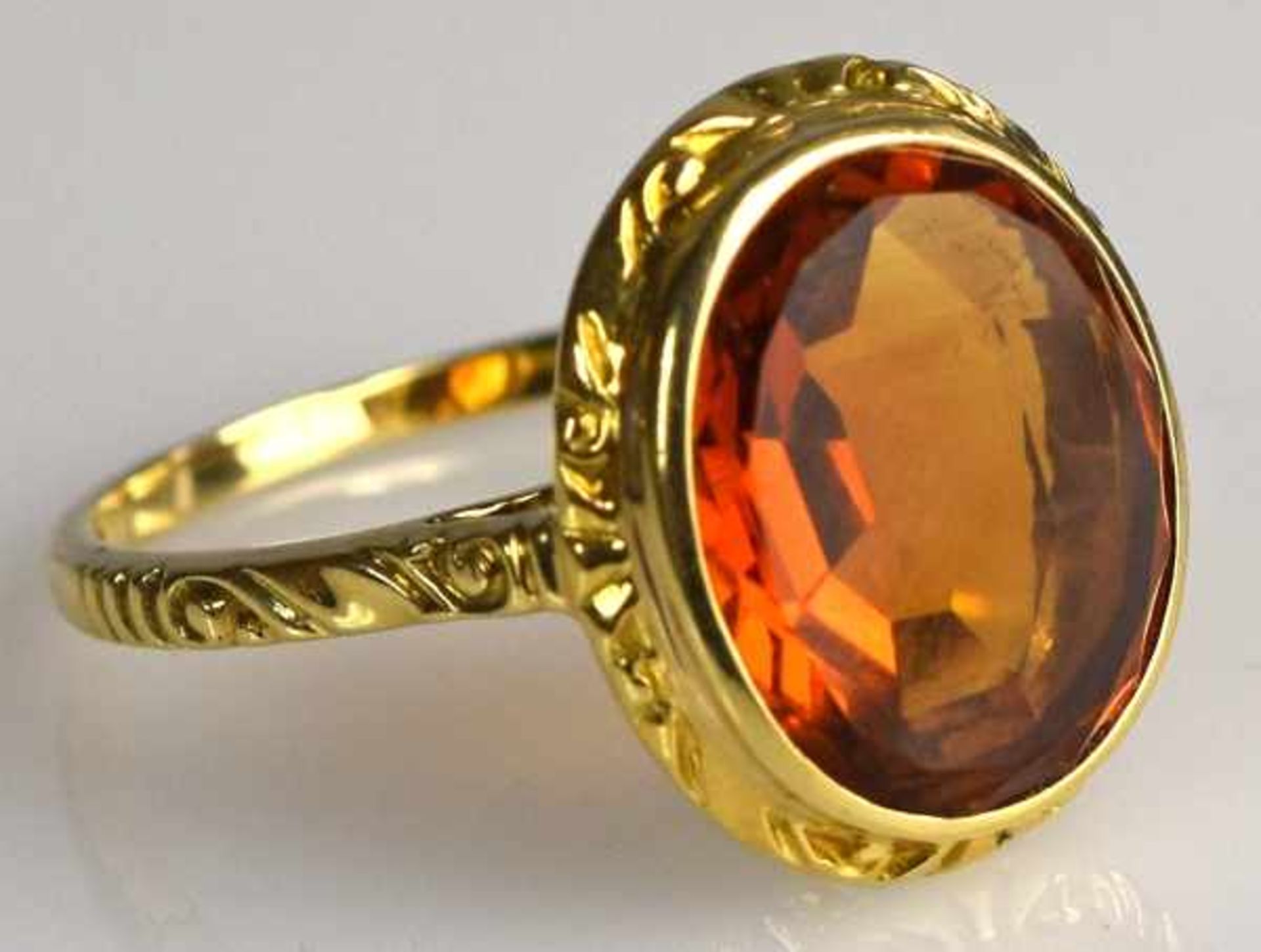 RING ovaler, orange farbener Stein, wohl Feueropal, im Bufftop-Schliff, in dekorierter Goldfassung