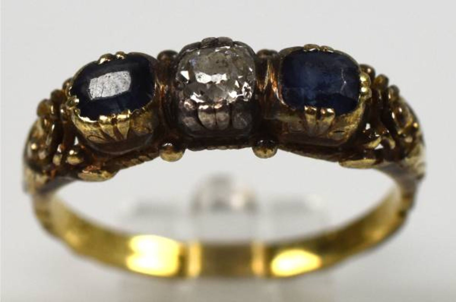 RING besetzt mit Altschliffdiamant um 0,2ct, mit seitlichen Saphiren, in dekorierter Fassung,