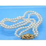 2 rhg. Akoja-Perlenkette und Schloss/ Brosche mit 3 Akojaperlen und 4 Brillanten, zusammen ca. 0,3