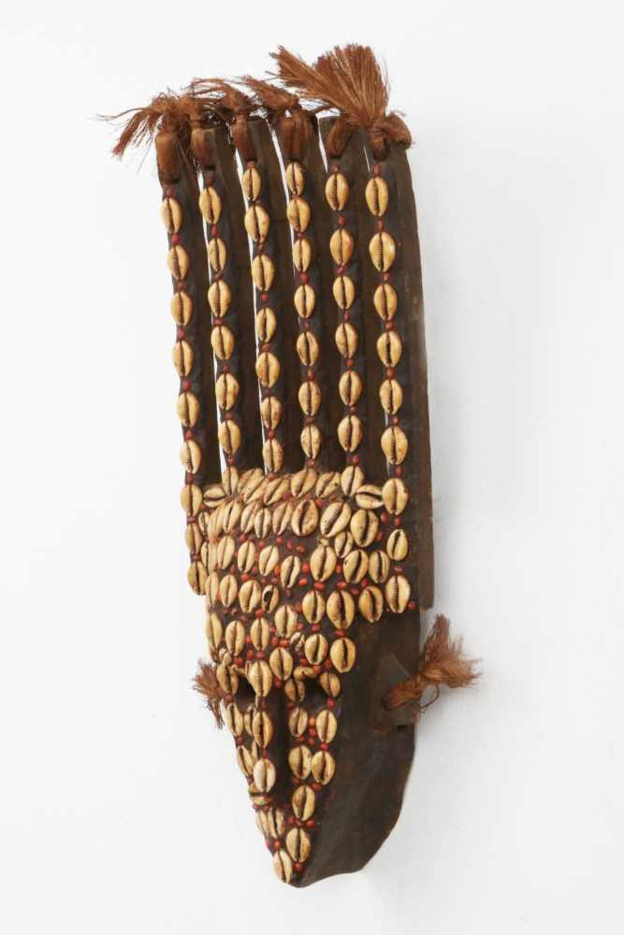 Afrikanische TanzmaskeHolz, geschnitzt, ebonisiert, mit Schneckenbesatz und Rafia Haar, wohl