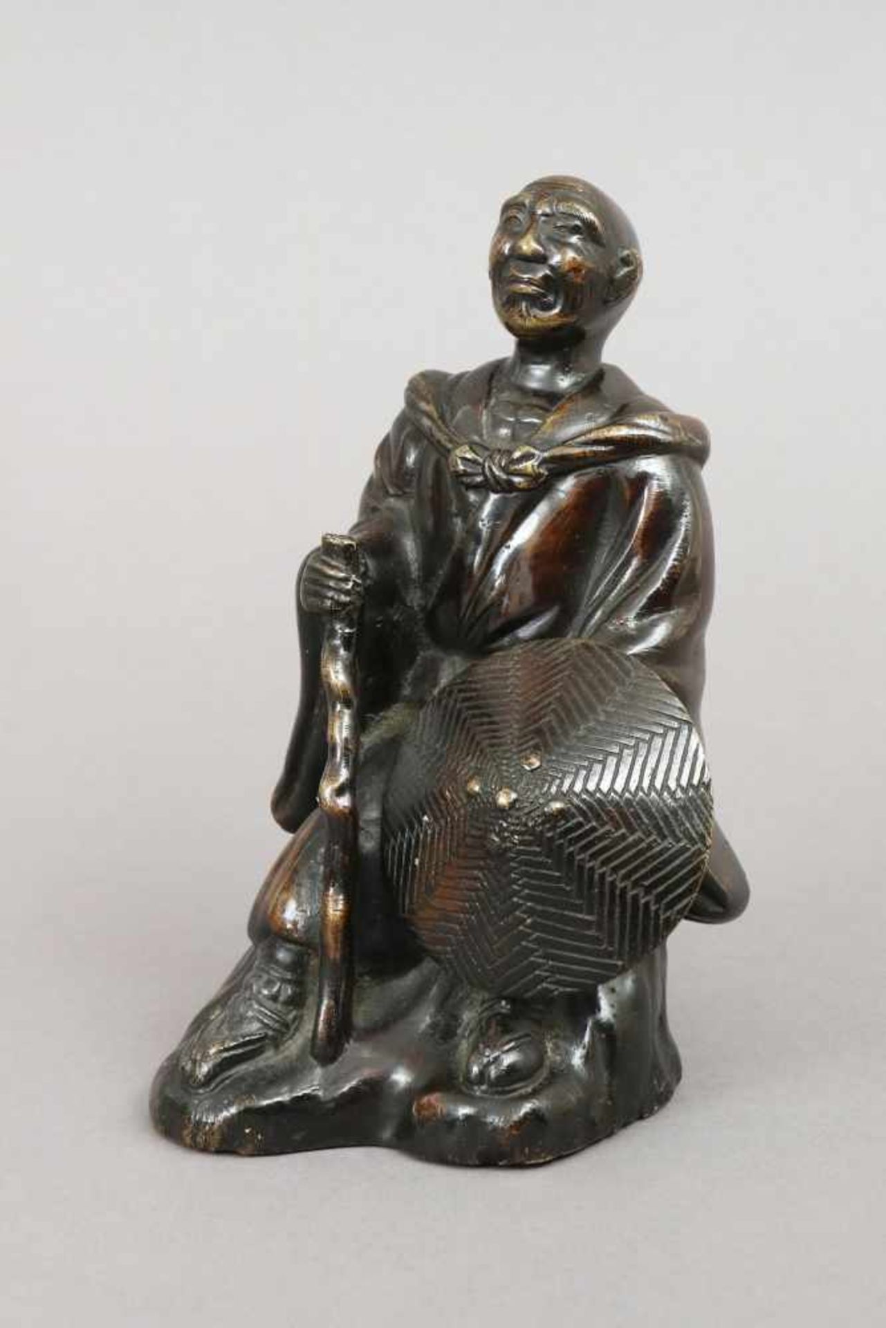 Chinesische Bronzefigur ¨Lohan¨Guss des späten 20. Jhdts., sitzende Darstellung mit Wanderstab