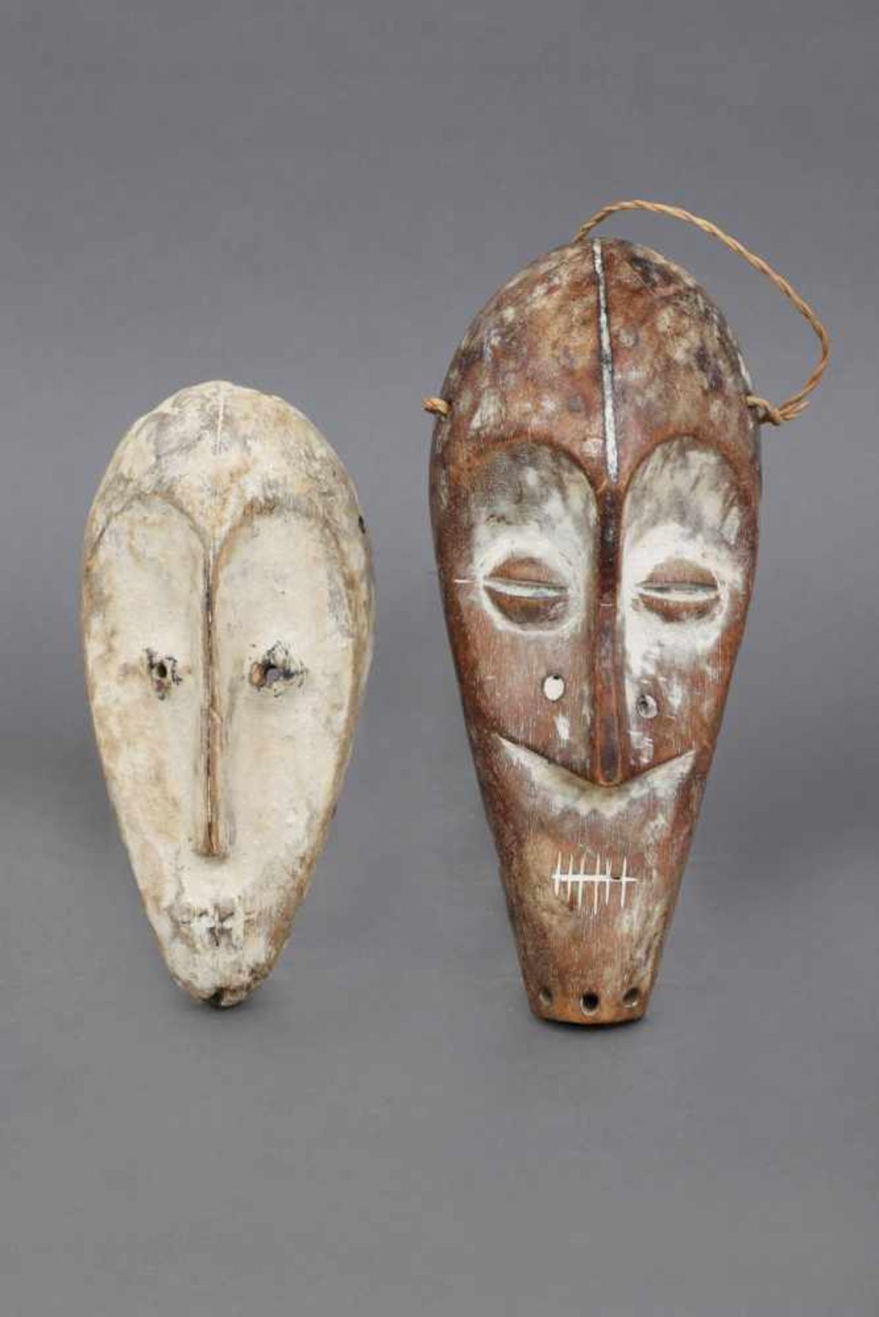2 afrikanische Passport-Masken wohl Kongo, Holz, mit Kaolin hell patiniert, H ca. 18 bzw. 23cm, aus