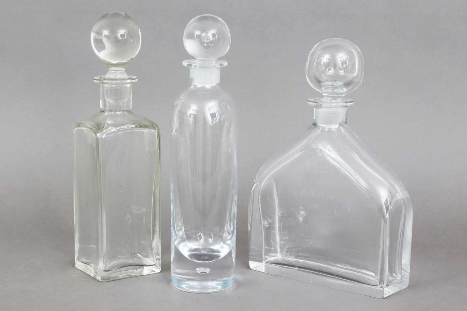 3 Kristallkaraffen mit Kugelstopfen farbloses Glas, diverse Formen (zylindrisch, hocheckig und
