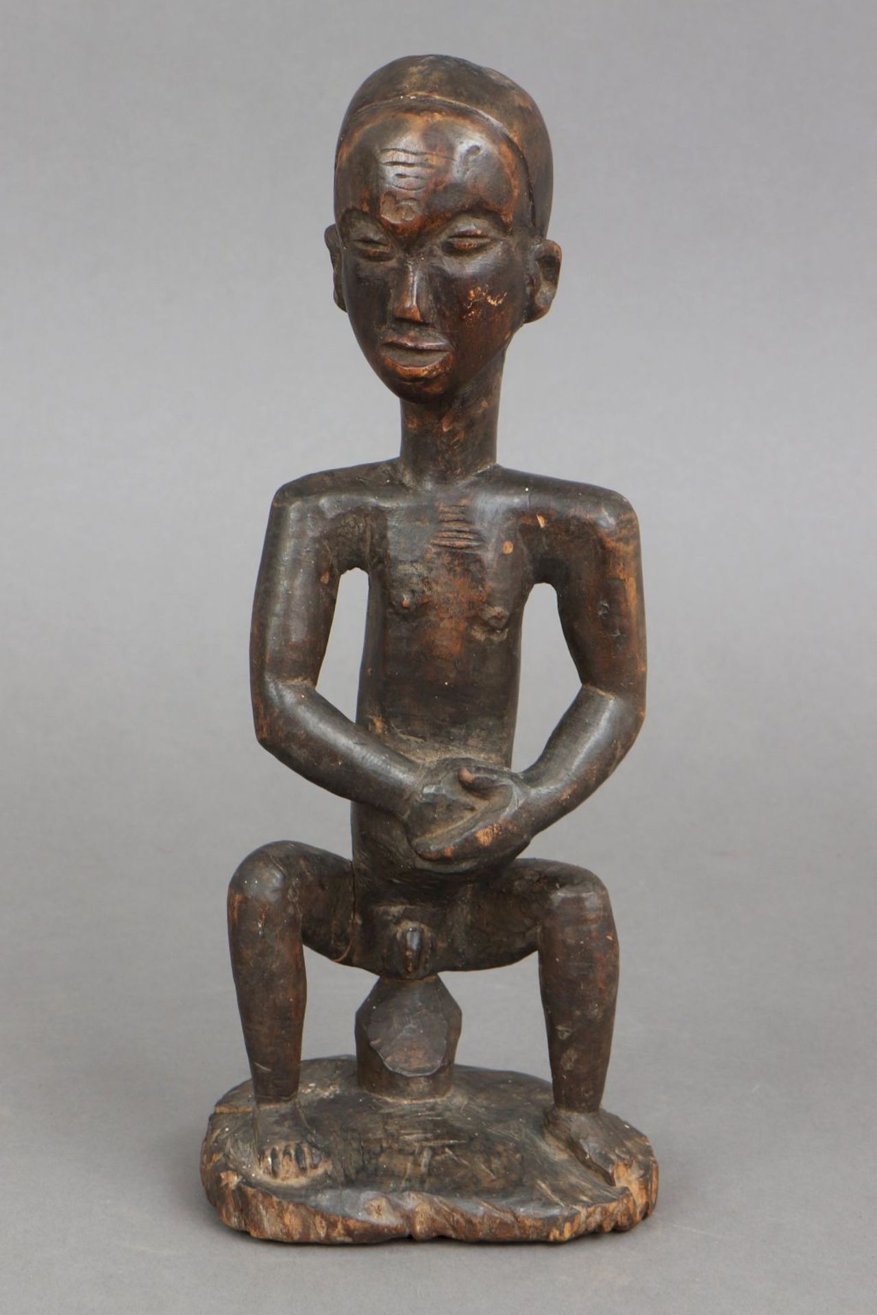 Afrikanische Ritualfigur (Medizinfigur), wohl Kongodunkel patiniertes Holz, auf Hocker sitzende