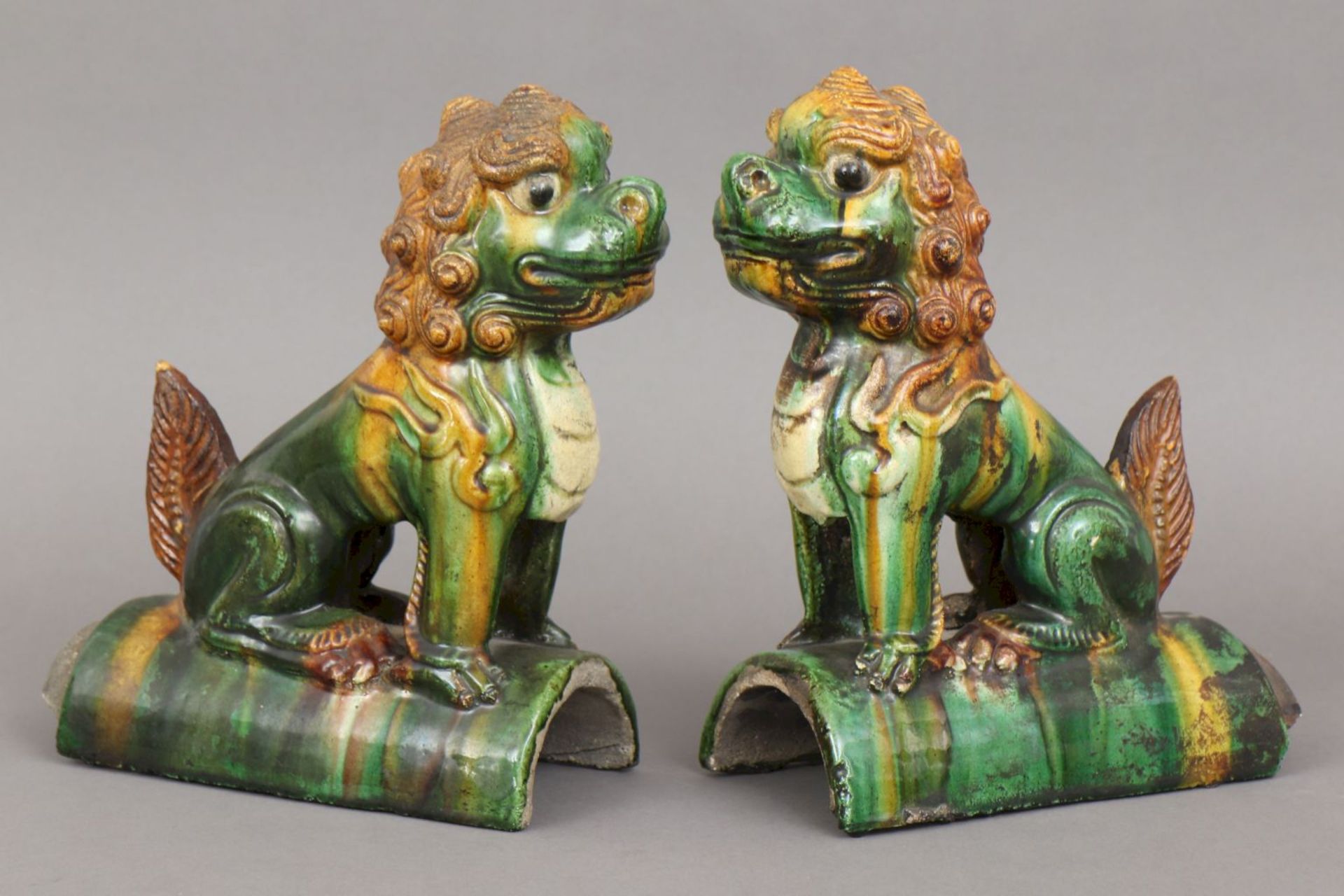 2 chinesische Dachfiguren, ¨Ming¨Steinzeug, glasiert, je sitzende Darstellung eines Drachenhu