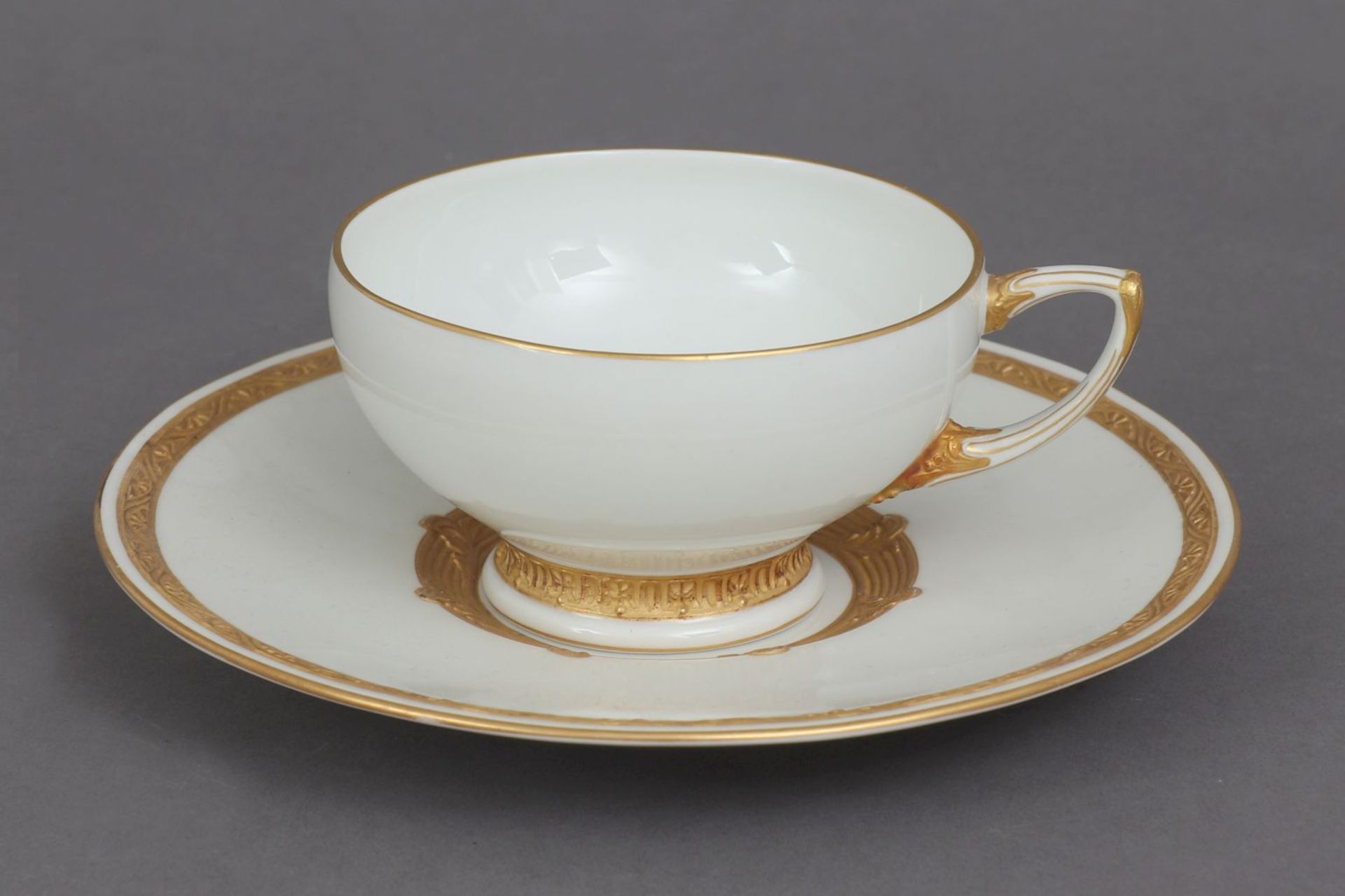 KPM BERLIN Teetasse mit Untertasseum 1920, Weißporzellan mit vegetabilem Ätzgold-Reliefrand,<