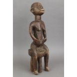 Afrikanische Ritualfigur, wohl Songye, Kongoauf Hocker sitzende weibliche Figur, die Hände an<