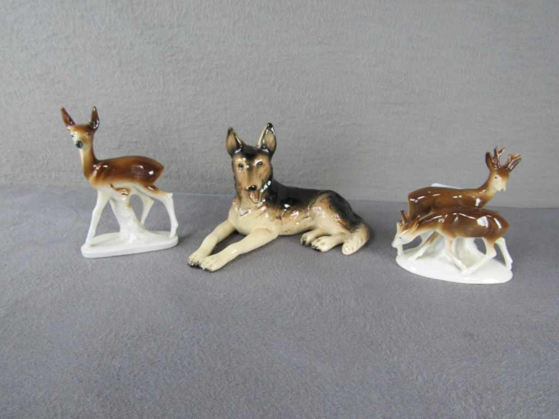 Drei Porzellanfiguren Rehe und Schäferhund<